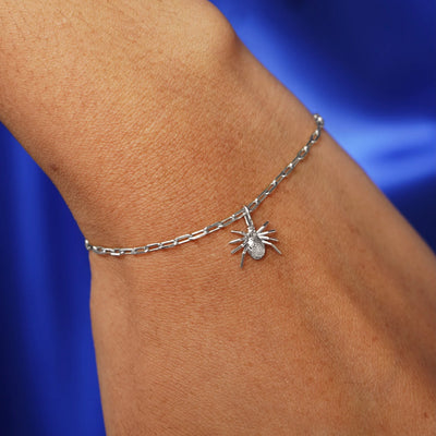 Close up view of a model's wrist wearing a white gold Spider Charm on a Butch Chain Bracelet