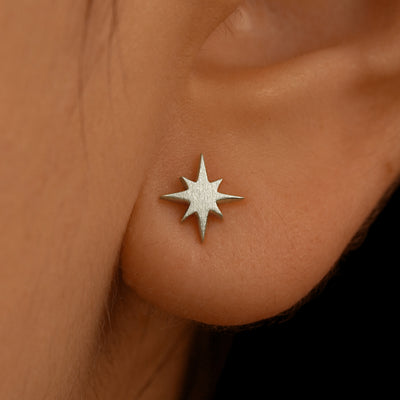 Close up view of a model's ear wearing a 14k white gold Starburst Earring