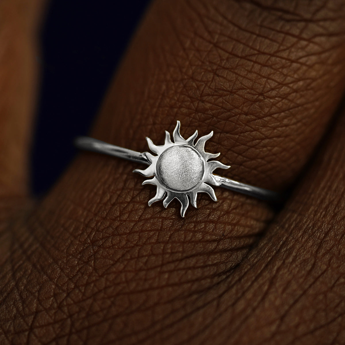 Close up view of a model's fingers wearing a 14k white gold Sun Ring