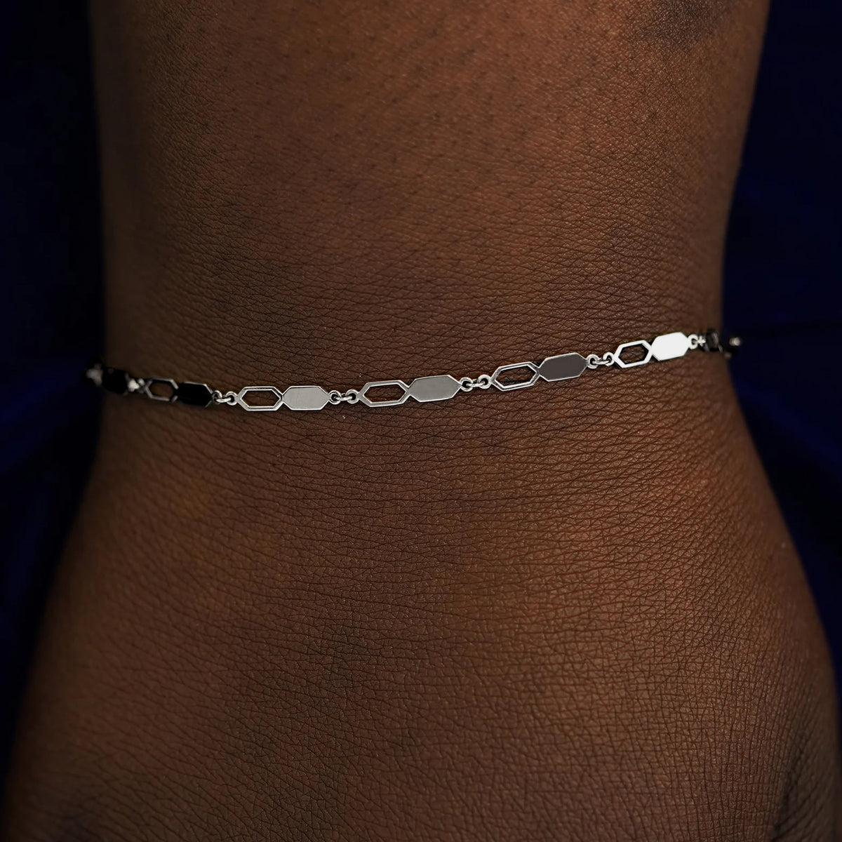 A model's wrist wearing a solid white gold Tanlah Bracelet