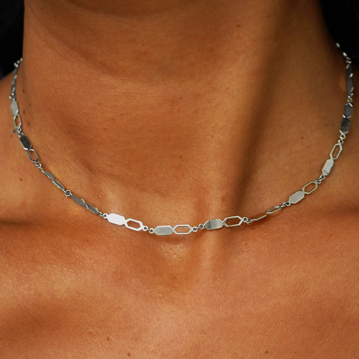 Close up view of a model's neck wearing a solid 14k white gold Tanlah Chain