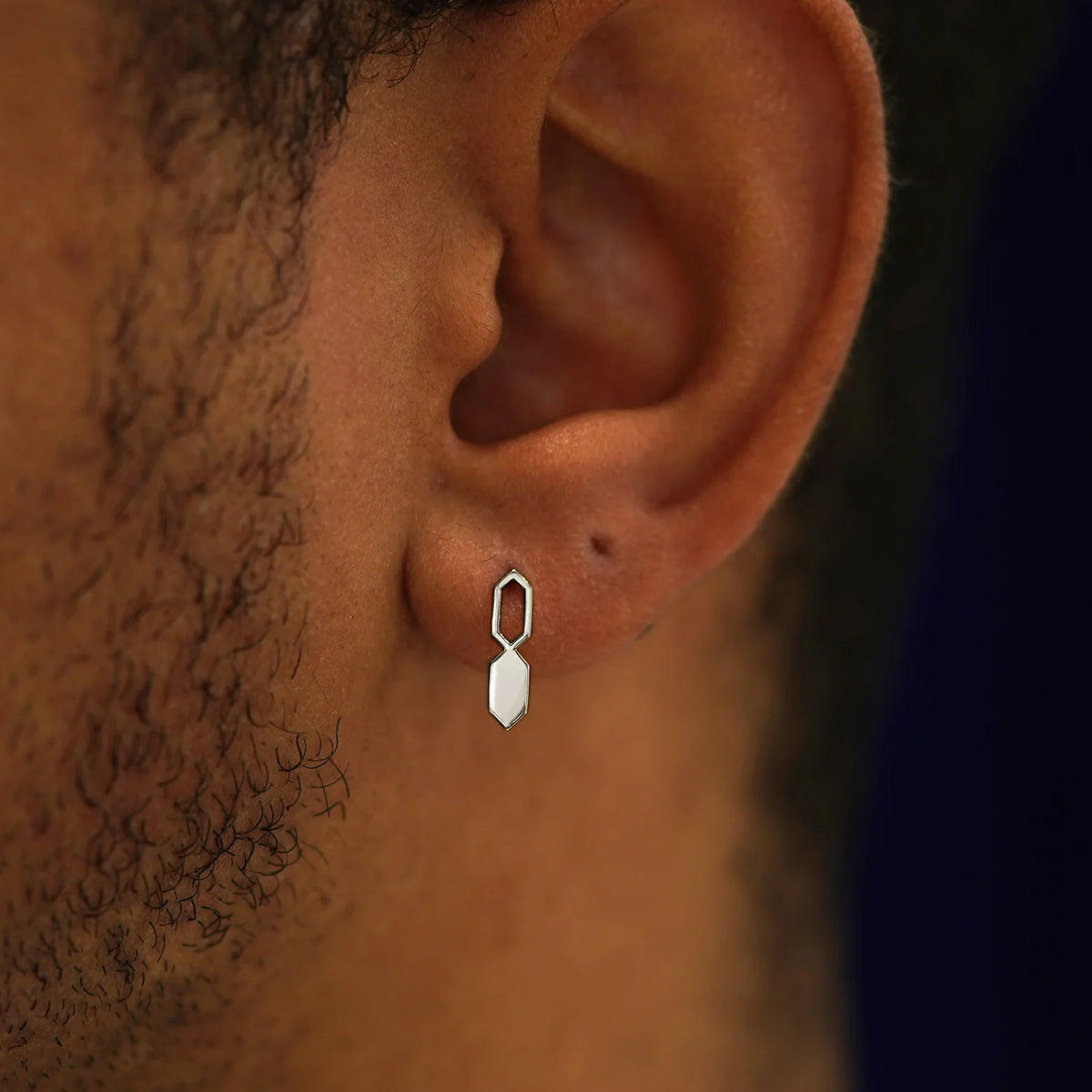 Close up view of a model's ear wearing a 14k white gold Tanlah Earring vertically