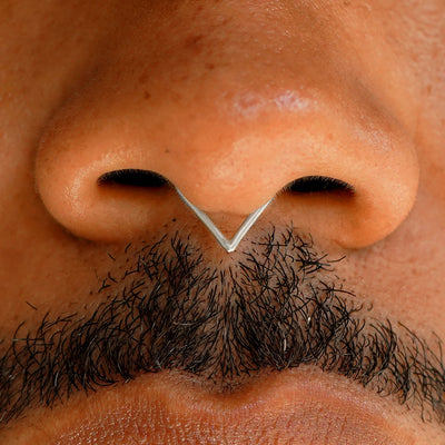 Close up view of a model's face wearing a 14k solid white gold Triangle Septum