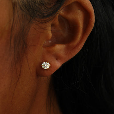 A model's ear wearing a 14k yellow gold clear 5mm Moissanite Earring