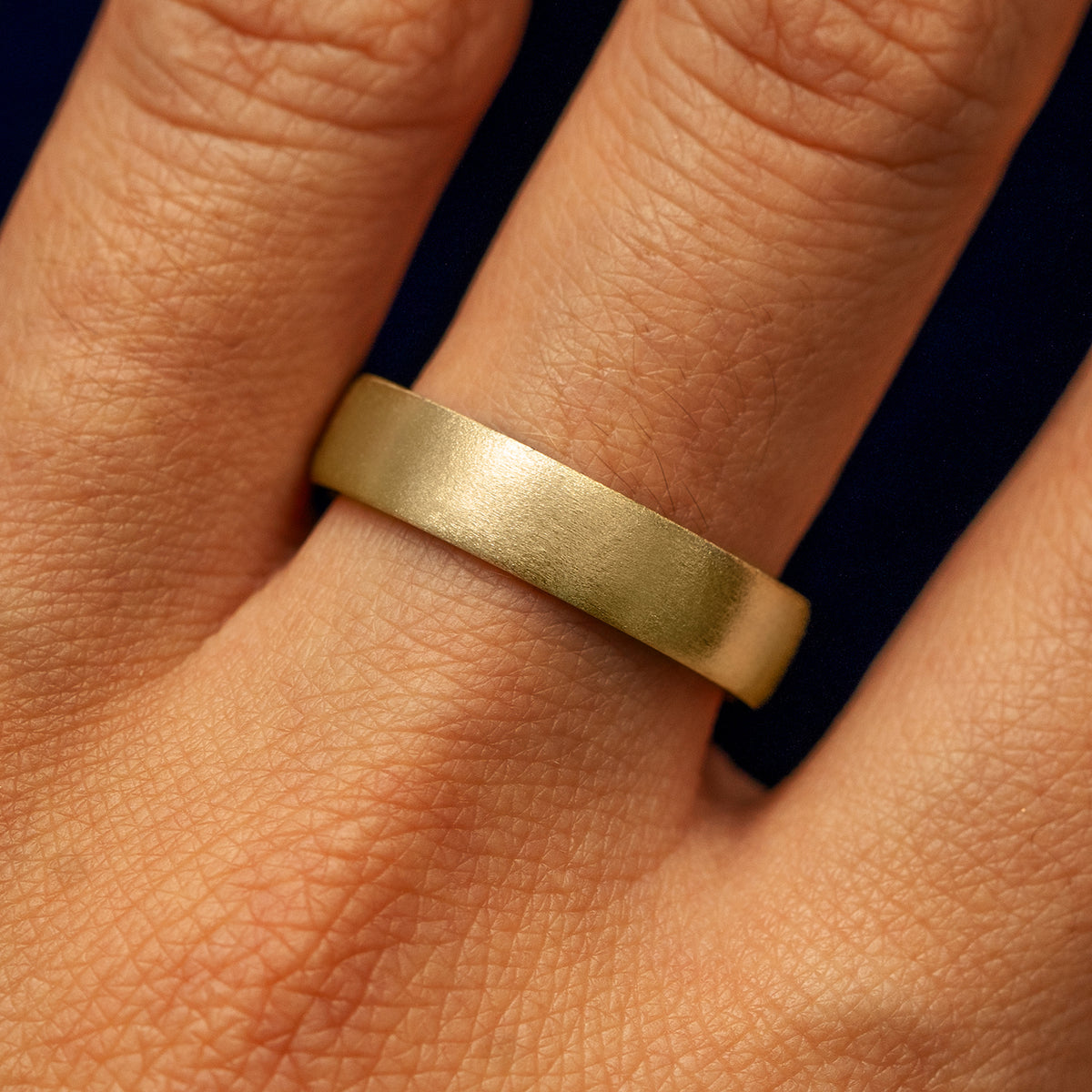 Close up view of a model's fingers wearing a 14k yellow gold Mix Matte Band