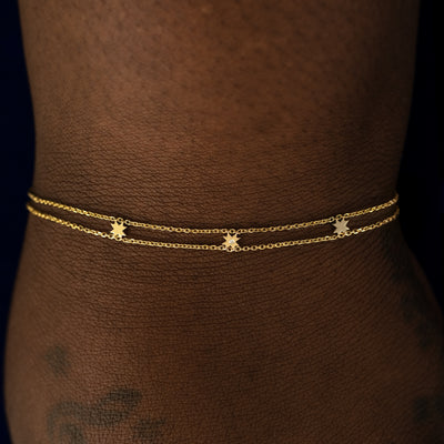 A model wearing a yellow gold 8 pointed star bracelet