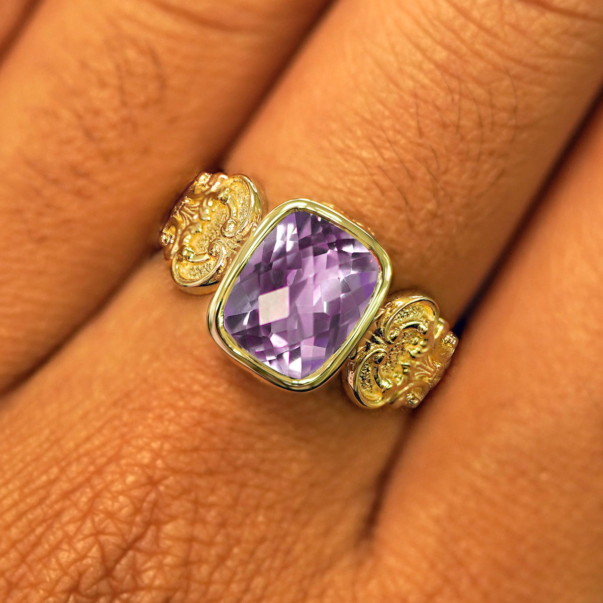 Close up view of a model's fingers wearing a yellow gold lavender amethyst Royalty Ring