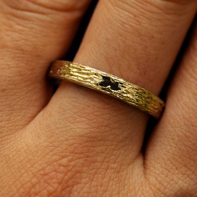 Close up view of a models fingers wearing a 14k yellow gold baguette diamond raw band