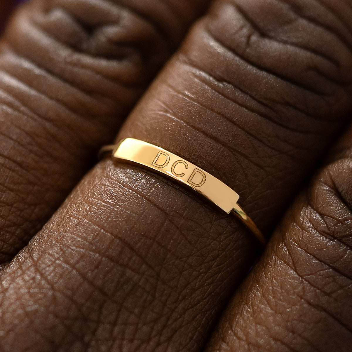 Close up view of a model's fingers wearing a yellow gold Bar Ring
