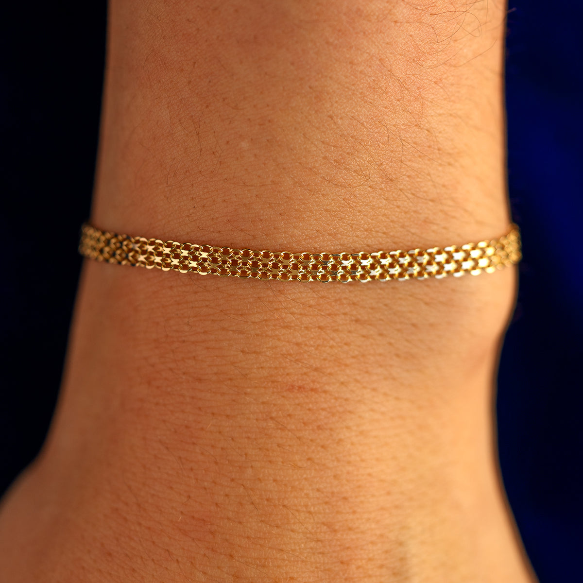 Close up view of a models wrist wearing a solid 14k yellow gold Bismark Chain Bracelet