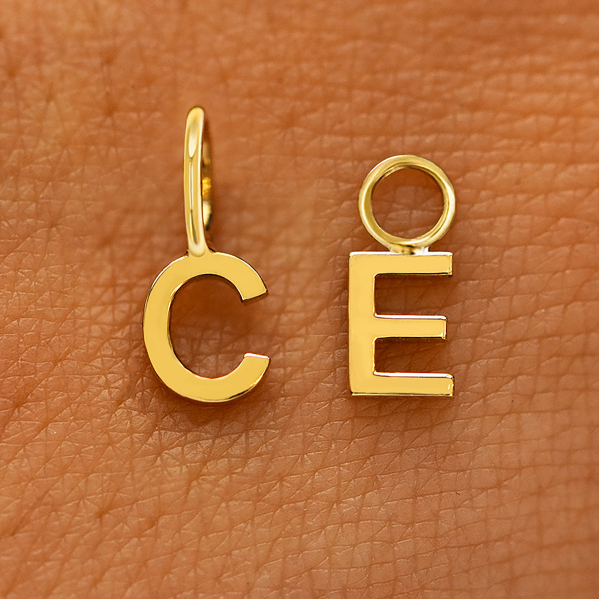 Two versions of the Block Initial Charm in the letters C and E showing For Chain and For Earring options in yellow gold