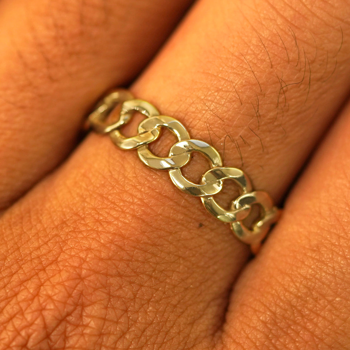 Close up view of a model's hand wearing a solid yellow gold Curb Ring