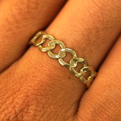Close up view of a model's hand wearing a solid yellow gold Curb Ring