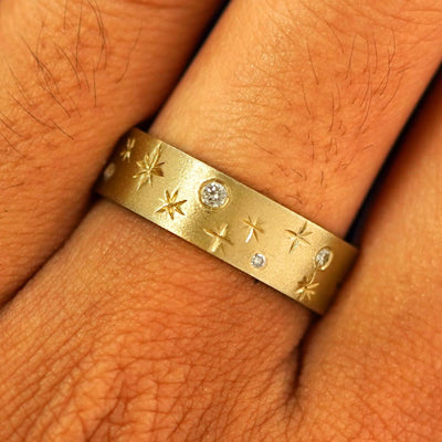Close up view of a model's fingers wearing a 14k yellow gold Stars and Diamonds Band