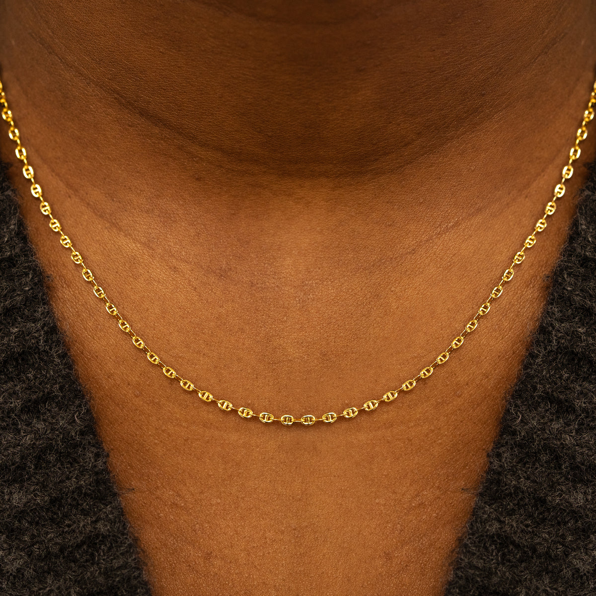 Close up view of a models neck wearing a solid 14k yellow gold Flat Mariner Chain Necklace