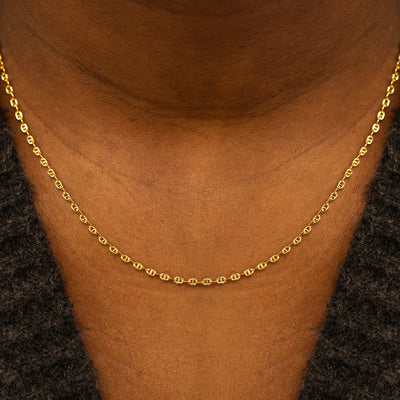 Close up view of a models neck wearing a solid 14k yellow gold Flat Mariner Chain Necklace