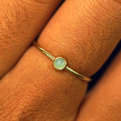 Close up view of a model's fingers wearing a 14k yellow gold Jade Ring