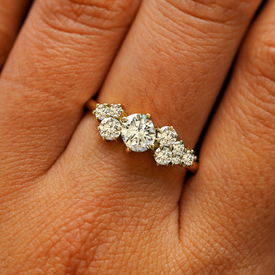 Close up view of a model's hand wearing a 14k yellow gold lab diamond cluster ring