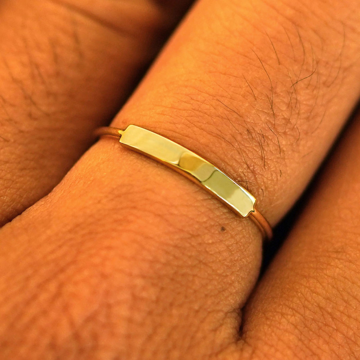 Close up view of a model's fingers wearing a yellow gold Bar Ring