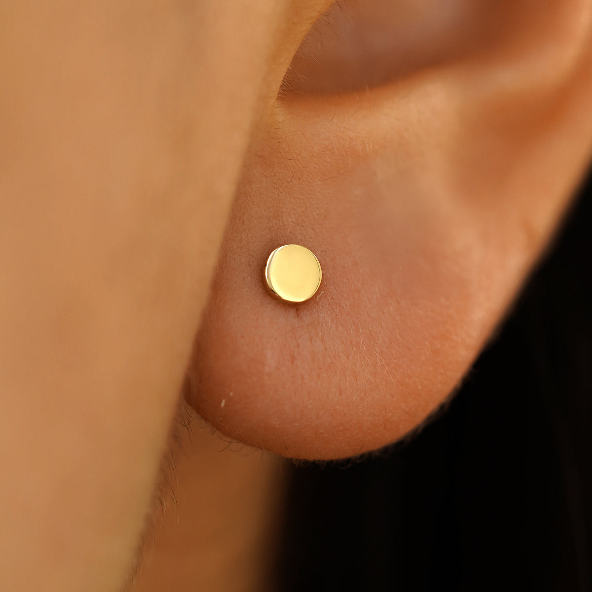 Close up view of a model's ear wearing a Medium Circle Earring in Yellow Gold.