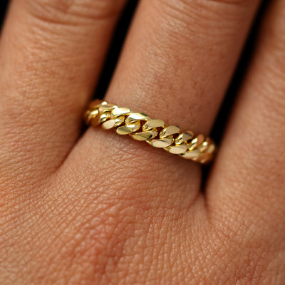 Close up view of a model's fingers wearing a 14k yellow gold Medium Miami Ring