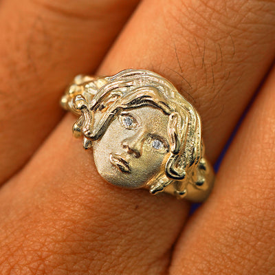 Close up view of a model's fingers wearing a 14k yellow gold Medusa Ring