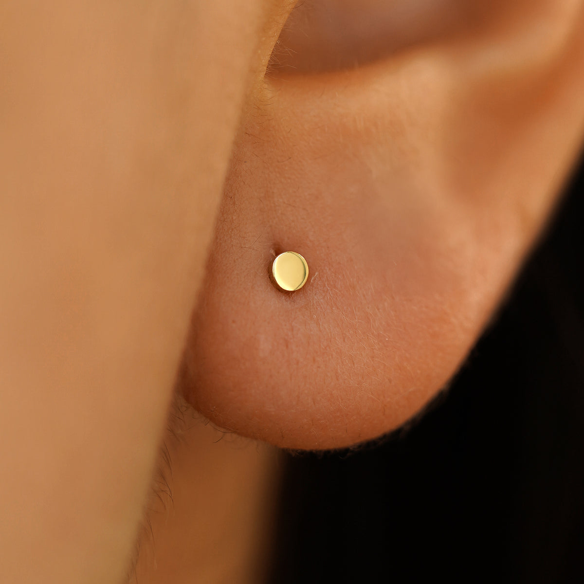 Close up view of mini circle earring on a model's ear