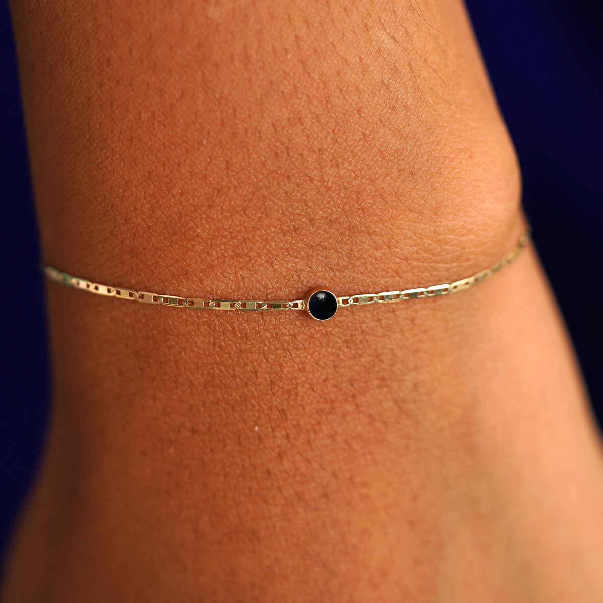 A model's wrist wearing a 14 karat yellow gold Onyx Bracelet