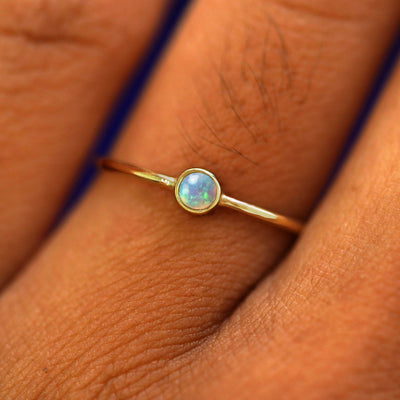 Close up view of a model's hand wearing a yellow gold Opal Ring