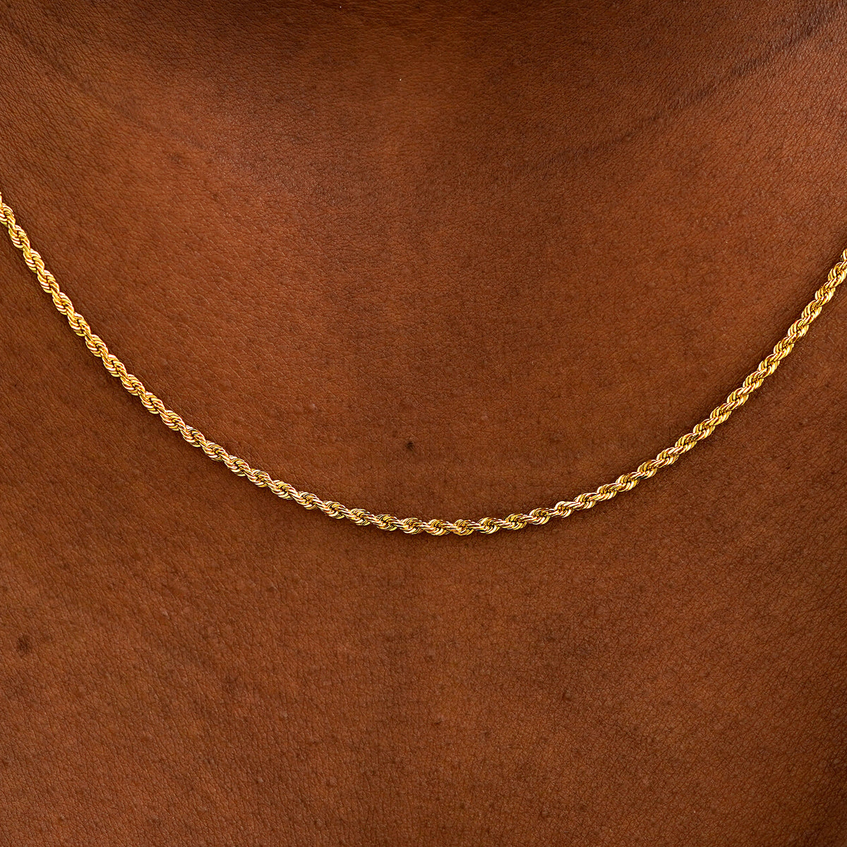Close up view of a model's neck wearing a solid yellow gold Rope Chain