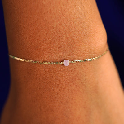 A model's wrist wearing a 14 karat yellow gold Rose Quartz Bracelet