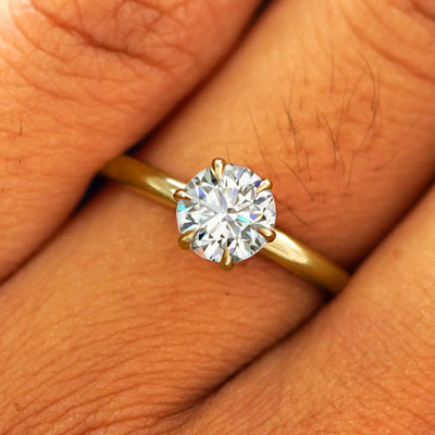 Close up view of a model's fingers wearing a 14k yellow gold Round Lab Diamond Ring