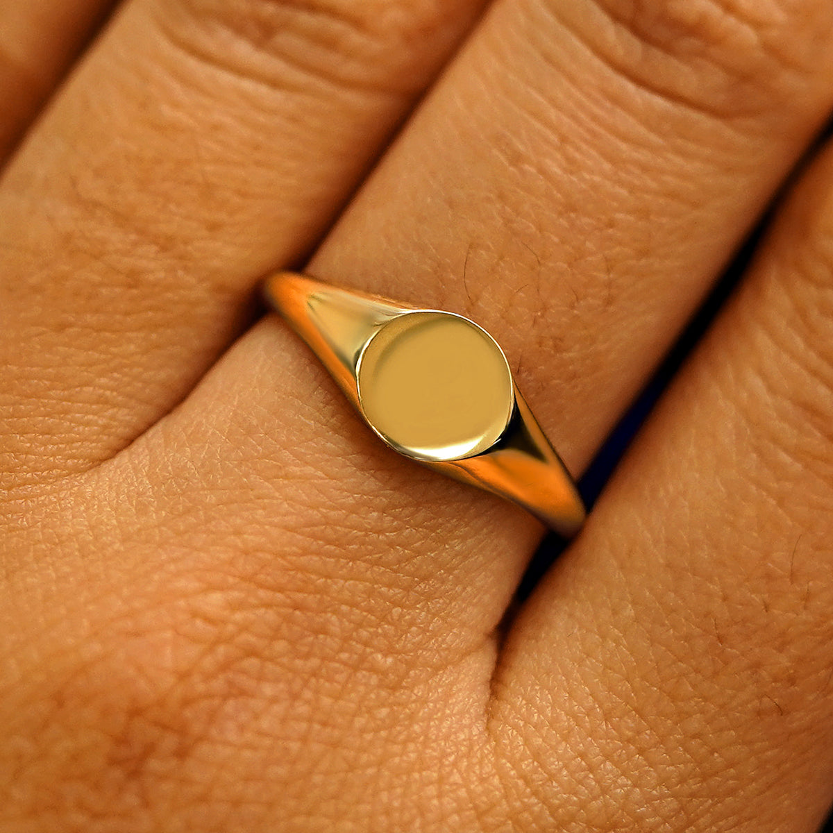 Close up view of a model's fingers wearing a 14k yellow gold Signet Ring