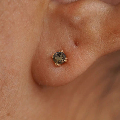 Close up view of a model's ear wearing a 14k yellow gold Rose Quartz Earring