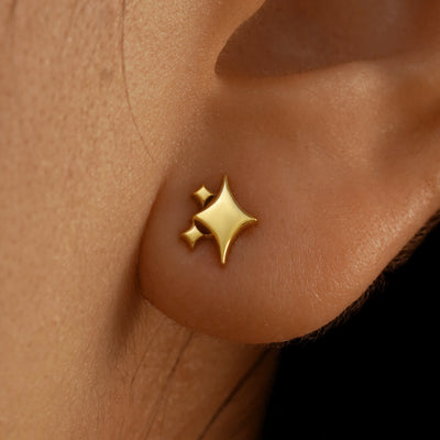Close up view of a model's ear wearing a 14k yellow gold Sparkly Emoji Earring