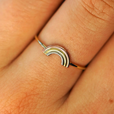 Close up view of a model's fingers wearing a solid yellow gold Rainbow Ring