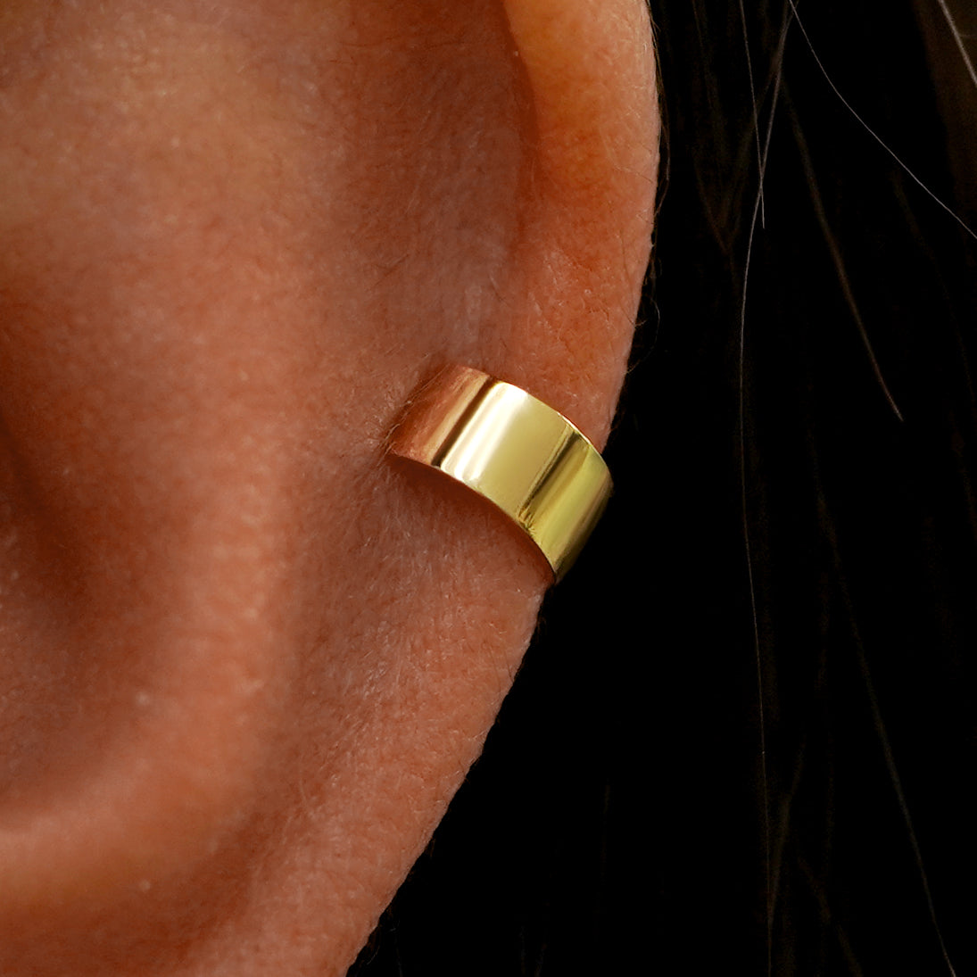 Close up view of a model's ear wearing a yellow gold Wide Cuff