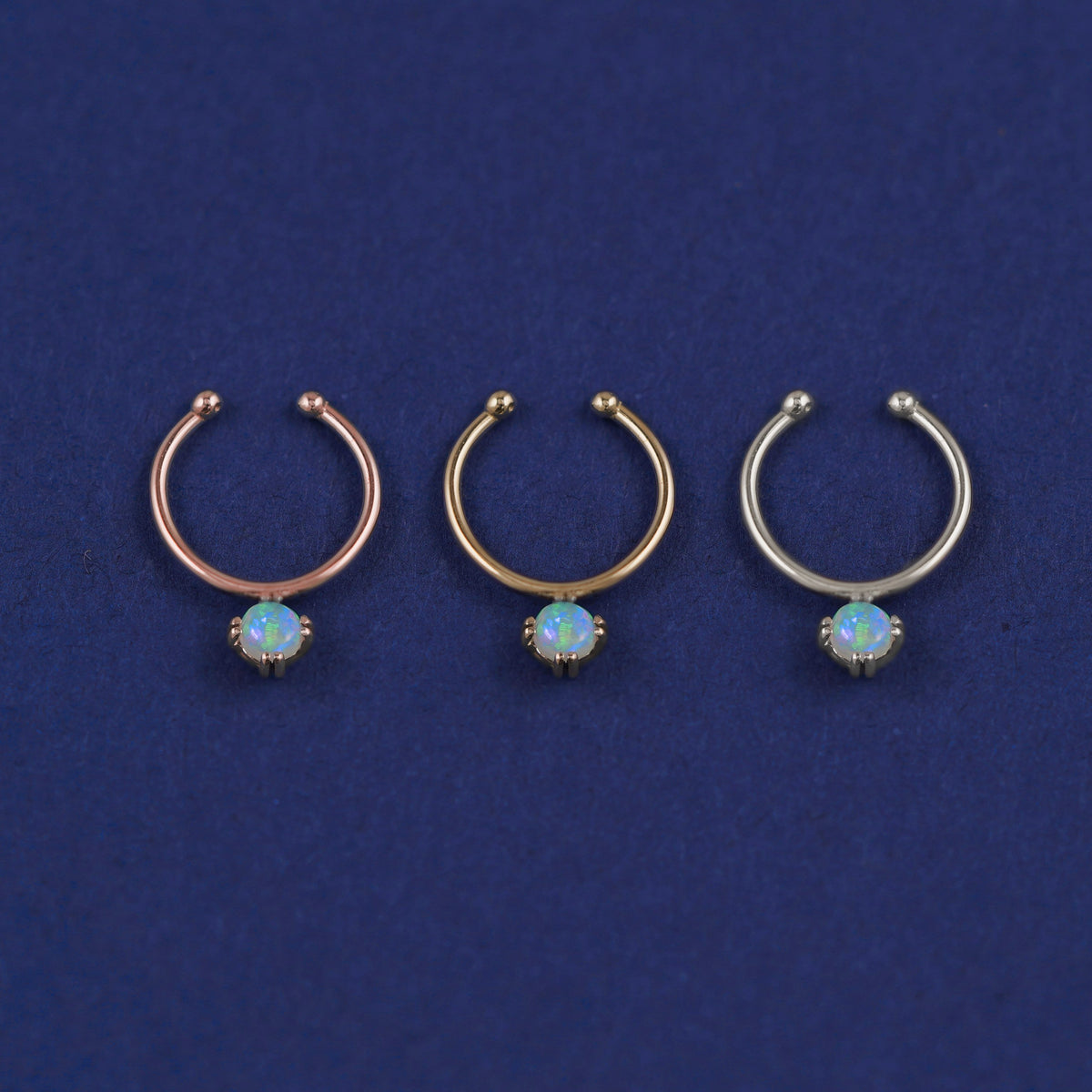 Three versions of the opal Non-Pierced Gemstone Septum shown in options of rose, yellow, and white gold