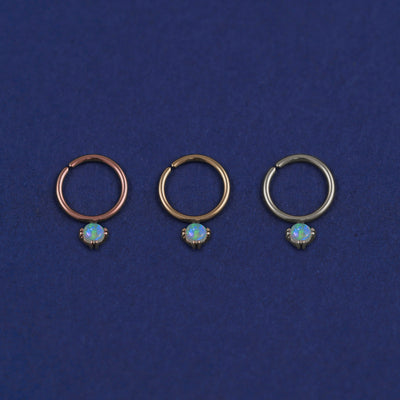 Three versions of the opal Pierced Gemstone Septum shown in options of rose, yellow, and white gold