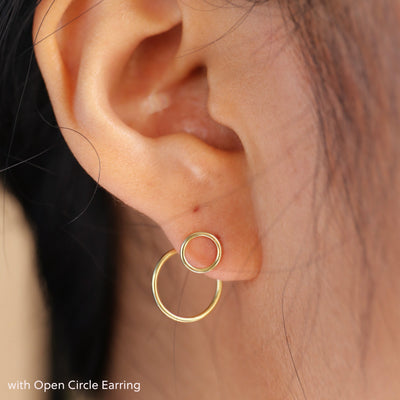 A model's ear wearing a yellow gold Open Circle Jacket with an Open Circle Earring