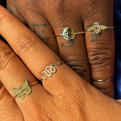 Close up view of two models holding hands wearing various Automic Gold rings