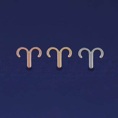 Three versions of the Aries Horoscope Earring shown in options of rose, yellow, and white gold